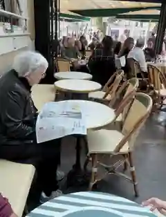雙叟咖啡館露台上一位客人閱讀報紙